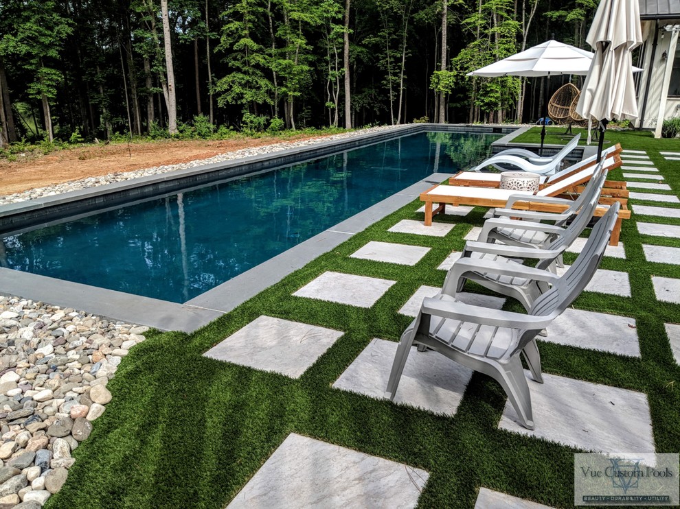 Foto di una grande piscina monocorsia minimal personalizzata dietro casa con piastrelle