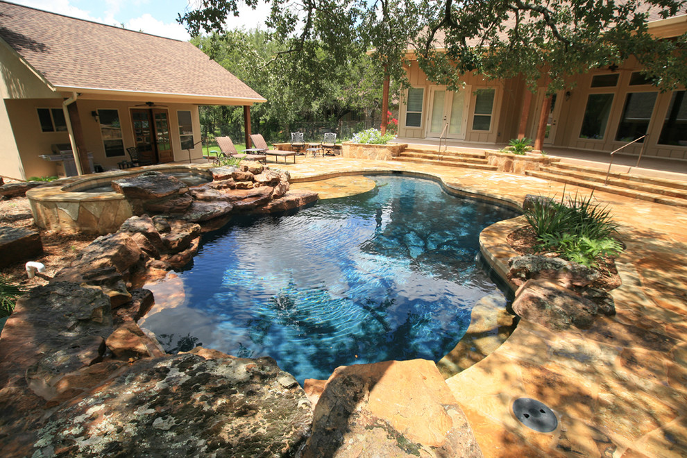 Réalisation d'une piscine arrière et naturelle chalet de taille moyenne et sur mesure avec un bain bouillonnant et des pavés en pierre naturelle.