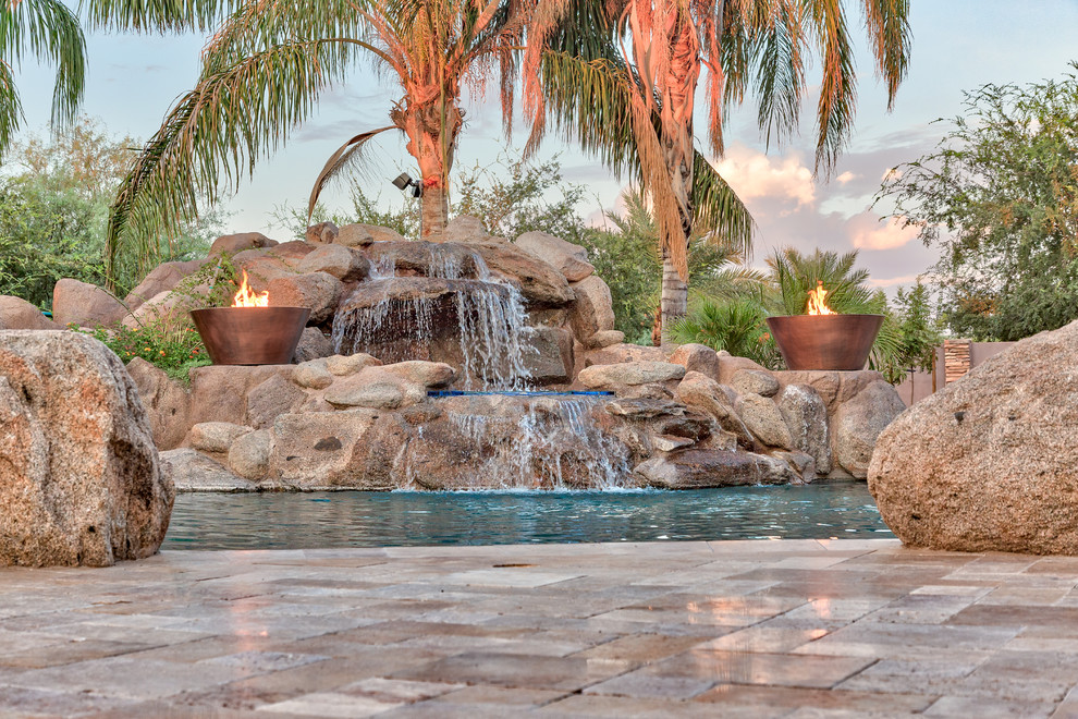 Cette image montre une grande piscine naturelle et arrière méditerranéenne avec des pavés en pierre naturelle.