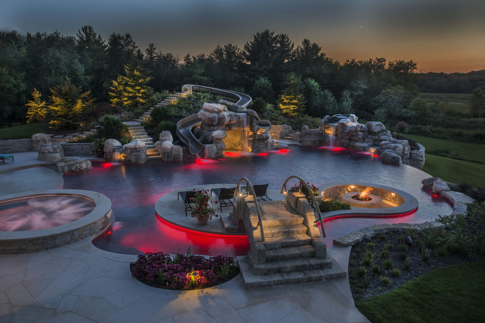 Ispirazione per una grande piscina a sfioro infinito personalizzata dietro casa con una vasca idromassaggio e pavimentazioni in pietra naturale