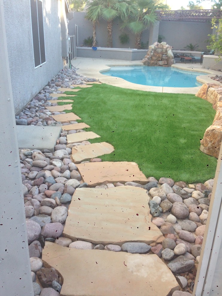 Imagen de piscina alargada clásica de tamaño medio a medida en patio trasero con losas de hormigón