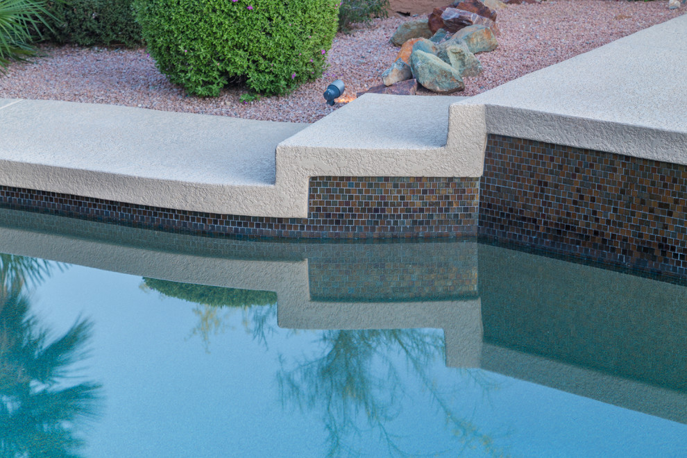 Modelo de piscina mediterránea de tamaño medio a medida en patio trasero con entablado