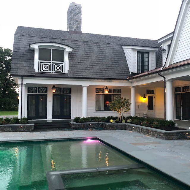 Foto de piscina infinita contemporánea rectangular en patio trasero con paisajismo de piscina y adoquines de piedra natural