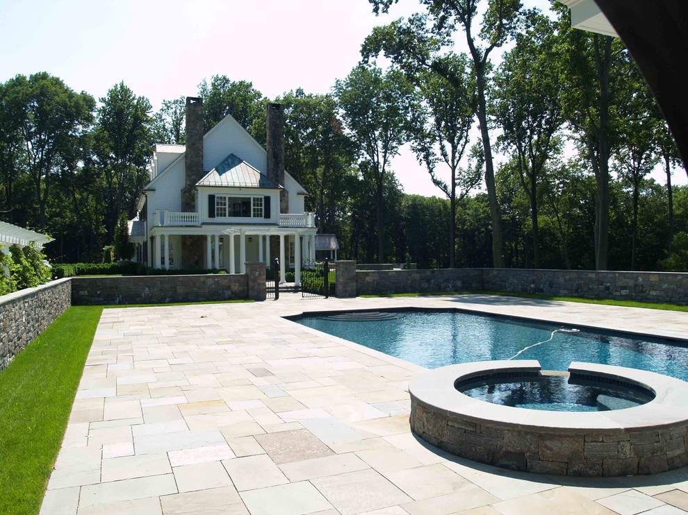 Foto på en stor vintage baddamm längs med huset, med poolhus och naturstensplattor