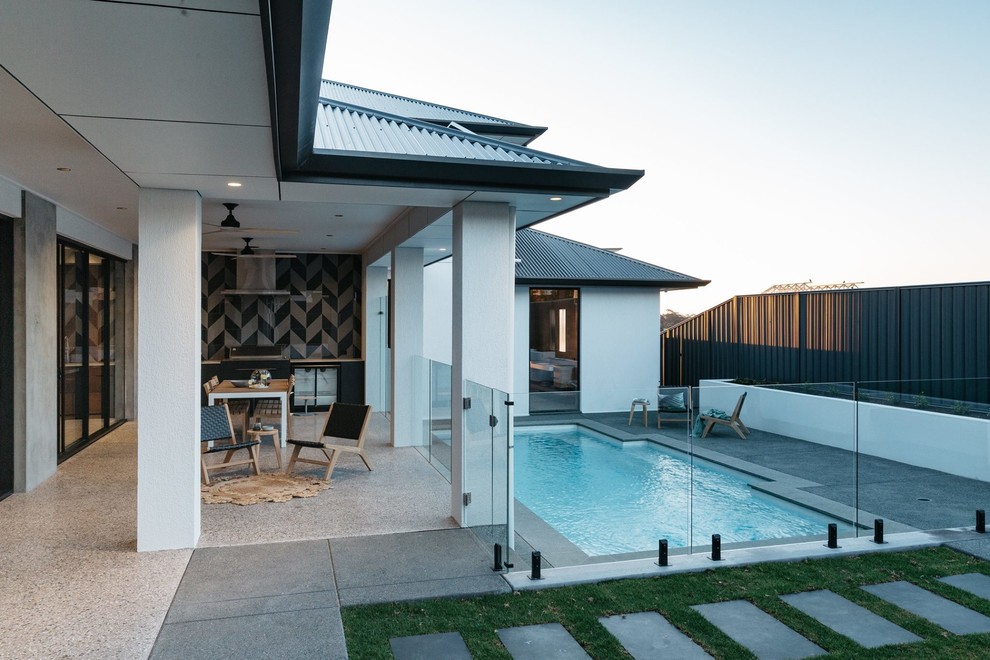 Foto de piscina con fuente natural contemporánea de tamaño medio rectangular en patio trasero con suelo de baldosas
