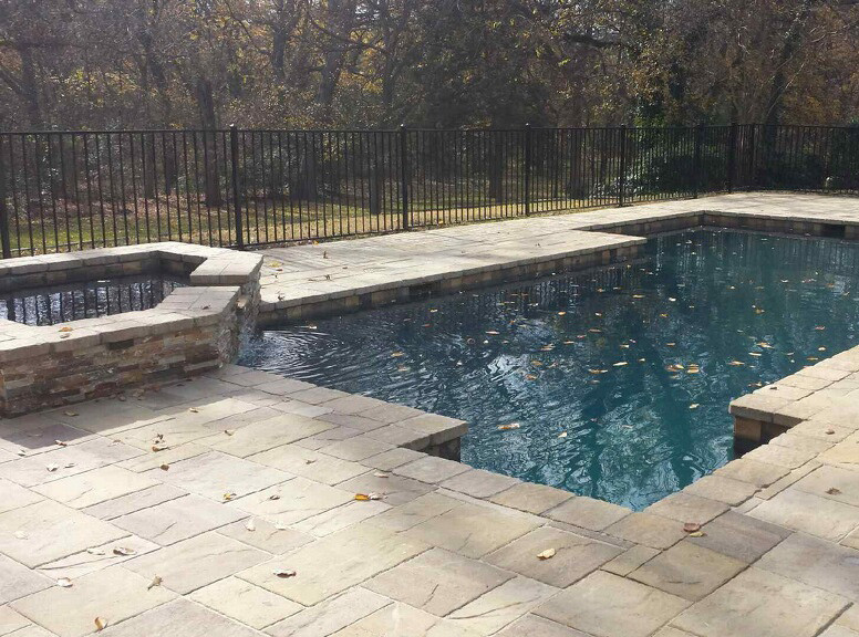 Mittelgroßer Uriger Pool hinter dem Haus in rechteckiger Form mit Natursteinplatten in Dallas