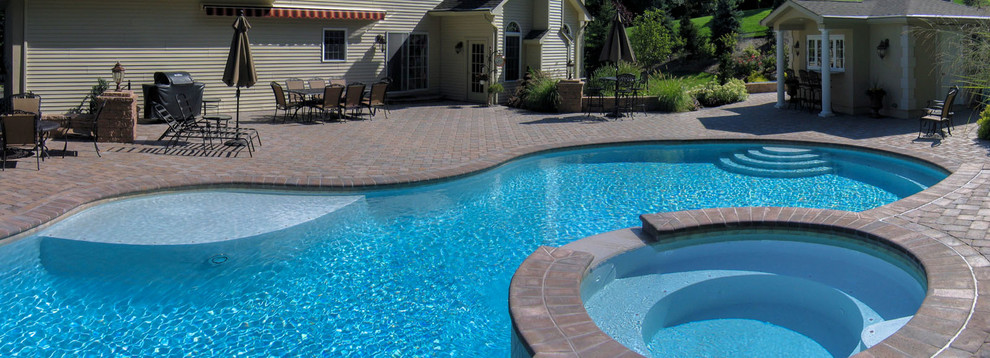 Idee per una piscina chic personalizzata dietro casa con pavimentazioni in cemento