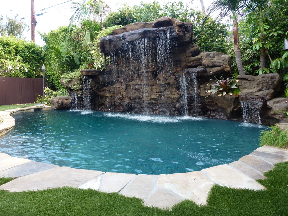 Imagen de piscina natural exótica pequeña a medida en patio trasero con losas de hormigón