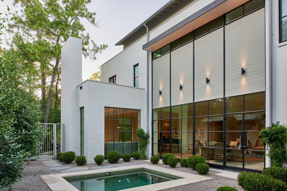 Modernes Pool mit Kies hinter dem Haus mit Wasserspiel in Houston