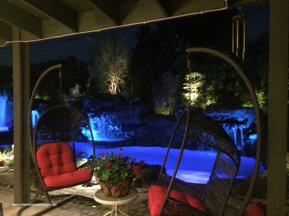 Diseño de piscina natural exótica grande a medida en patio trasero