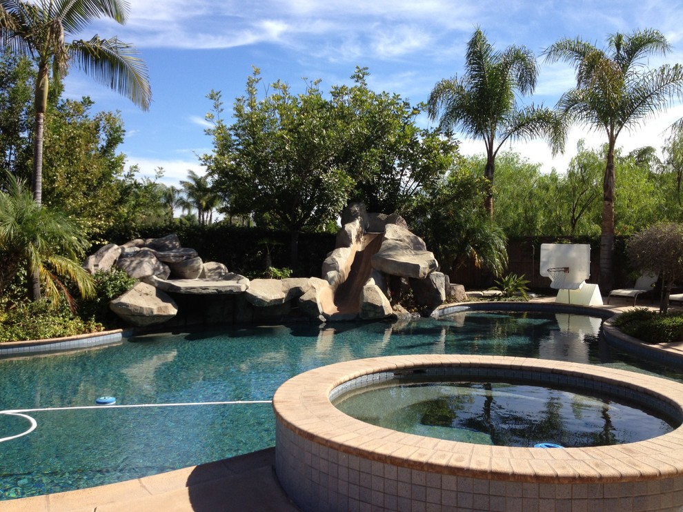 Inspiration for a tropical backyard concrete and custom-shaped pool fountain remodel in San Diego