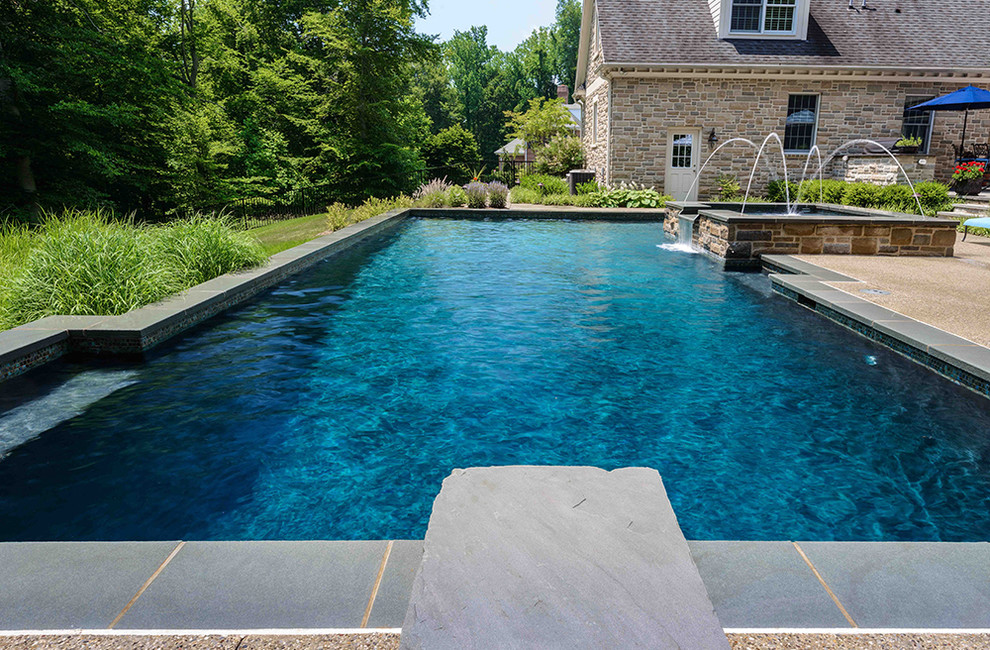 Idee per una grande piscina chic personalizzata dietro casa con lastre di cemento e una vasca idromassaggio