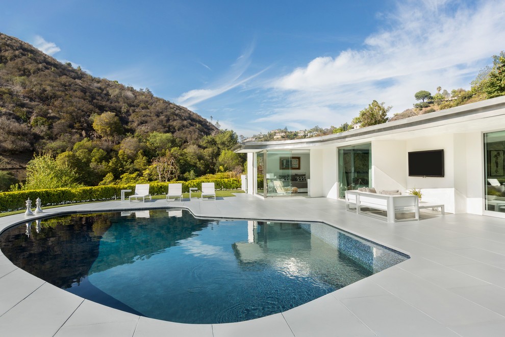 Pool - mid-century modern backyard concrete and kidney-shaped pool idea in Los Angeles