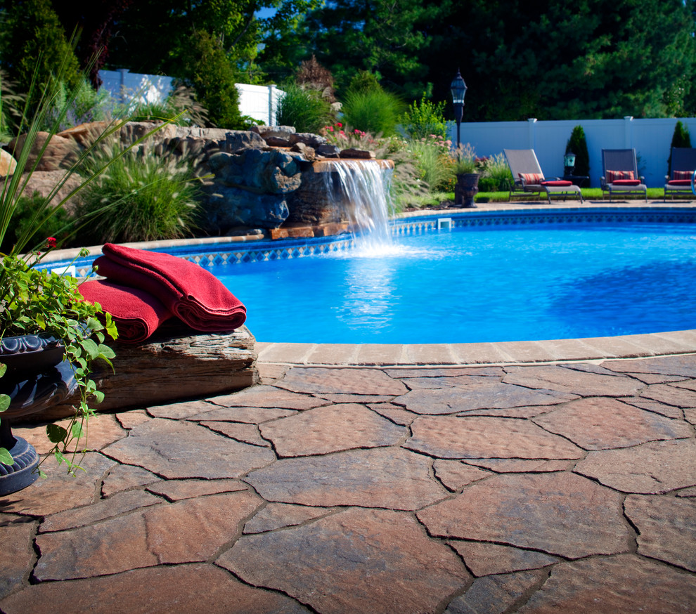 Modelo de piscina con fuente alargada tradicional renovada de tamaño medio rectangular en patio trasero con adoquines de ladrillo