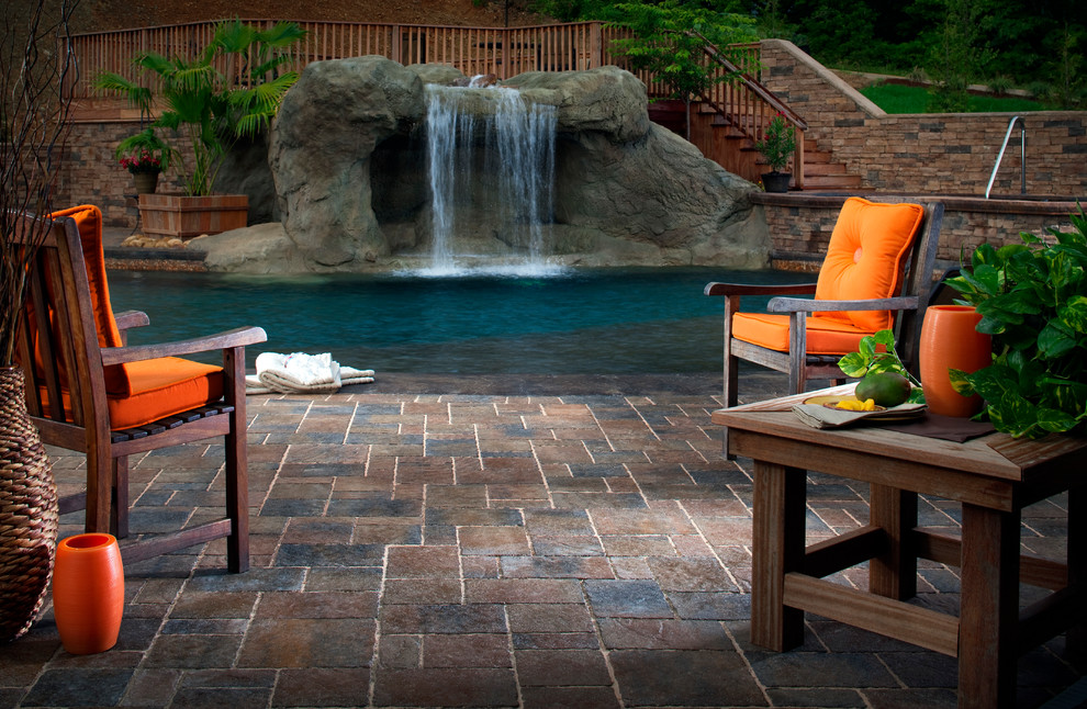 На фото: большой естественный, прямоугольный бассейн на заднем дворе в стиле неоклассика (современная классика) с фонтаном и покрытием из каменной брусчатки