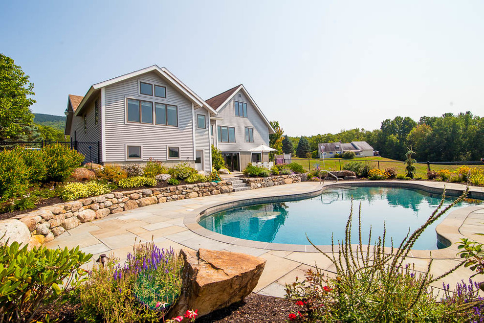 Ispirazione per una grande piscina naturale chic personalizzata dietro casa con piastrelle