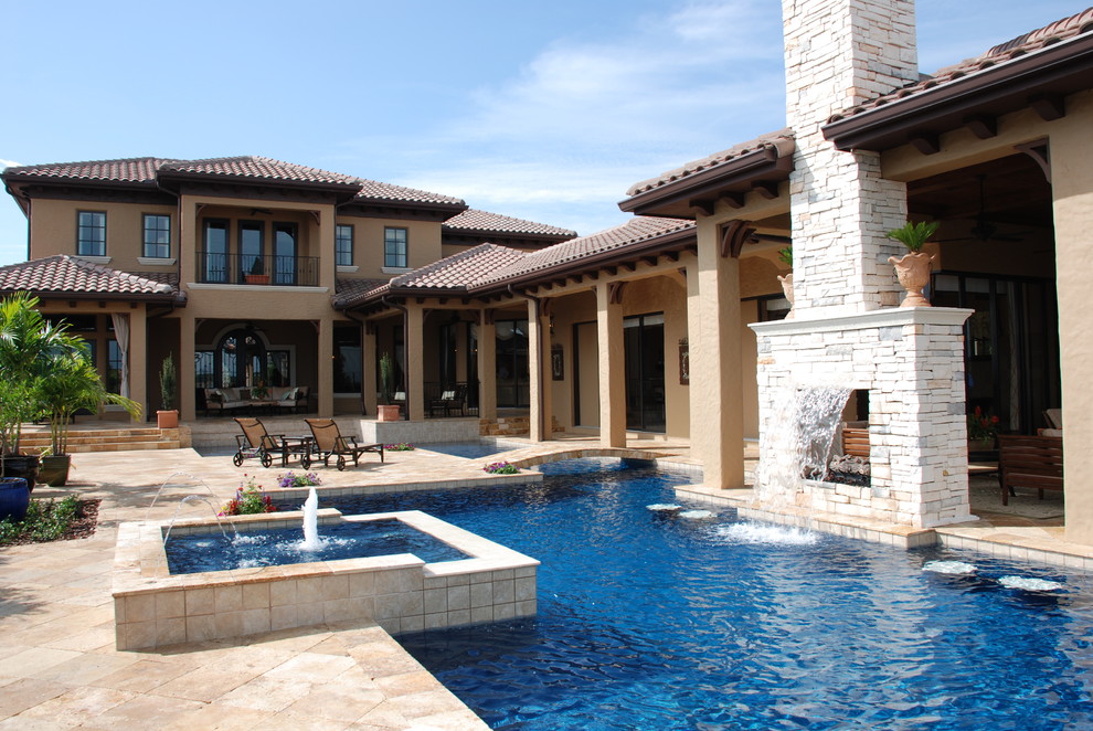 Foto på en mellanstor medelhavsstil pool på baksidan av huset, med kakelplattor