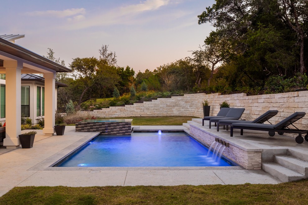 Inspiration for a contemporary back rectangular lengths swimming pool in Austin with a water feature and concrete slabs.
