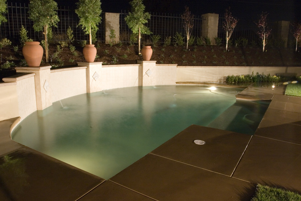 Cette photo montre une piscine arrière méditerranéenne de taille moyenne et sur mesure avec une dalle de béton.