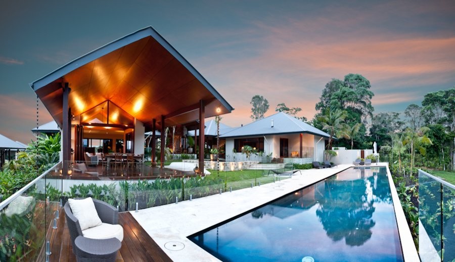 Foto de casa de la piscina y piscina alargada tropical extra grande rectangular en patio con adoquines de piedra natural