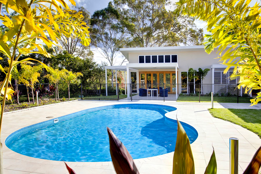 Immagine di una piscina moderna a "C" di medie dimensioni e dietro casa
