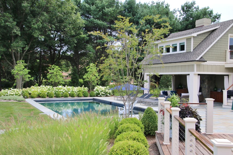 Esempio di una grande piscina naturale classica rettangolare dietro casa con una dépendance a bordo piscina e pavimentazioni in pietra naturale