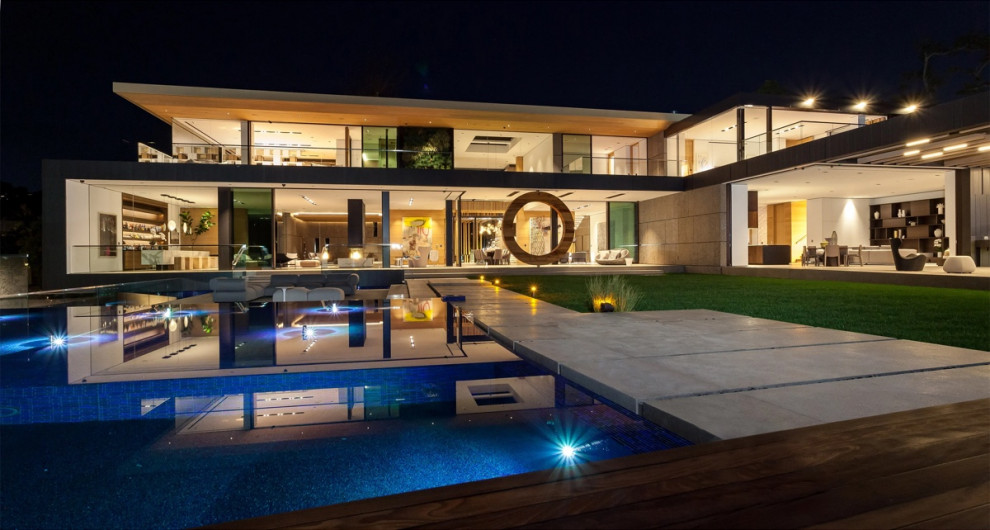 Idee per un'ampia piscina a sfioro infinito design personalizzata dietro casa con fontane e pedane