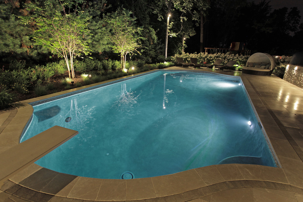 Modelo de piscinas y jacuzzis alargados de estilo americano grandes a medida en patio trasero con suelo de baldosas