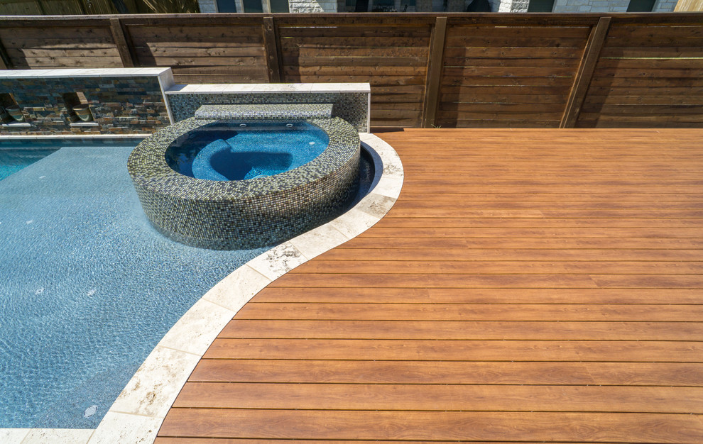 Пример оригинального дизайна: бассейн среднего размера, произвольной формы на заднем дворе в современном стиле с джакузи и настилом