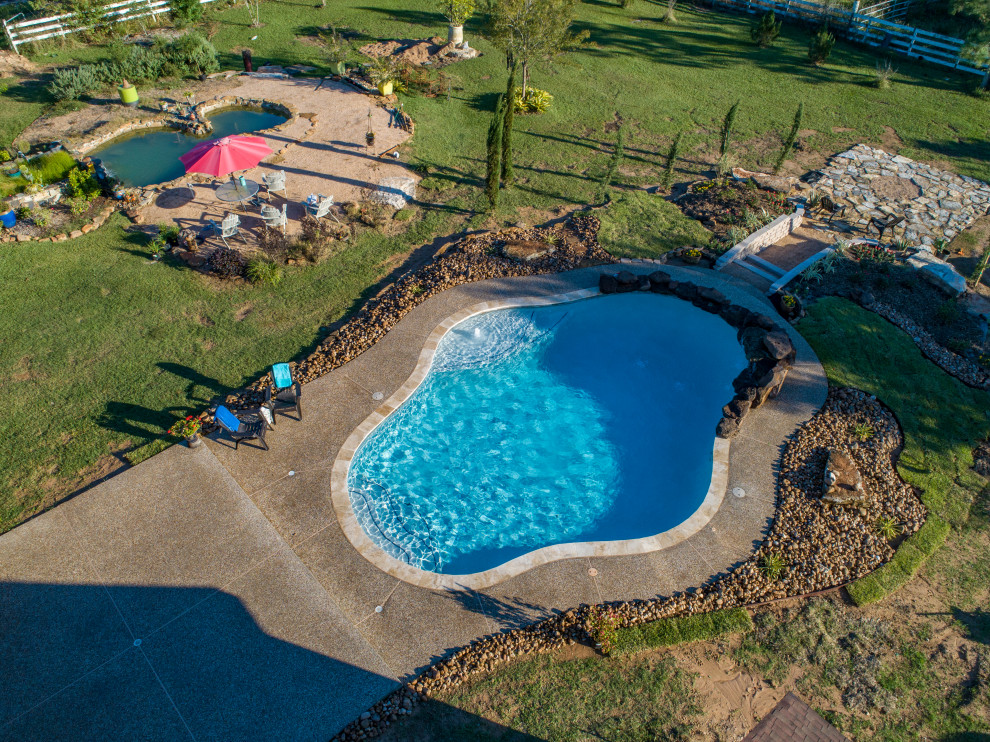 Foto de piscina rústica de tamaño medio a medida en patio trasero con entablado