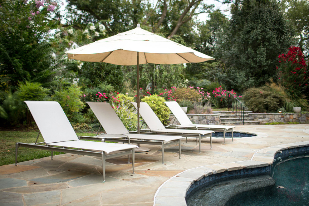 Imagen de casa de la piscina y piscina natural actual a medida en patio trasero con adoquines de piedra natural