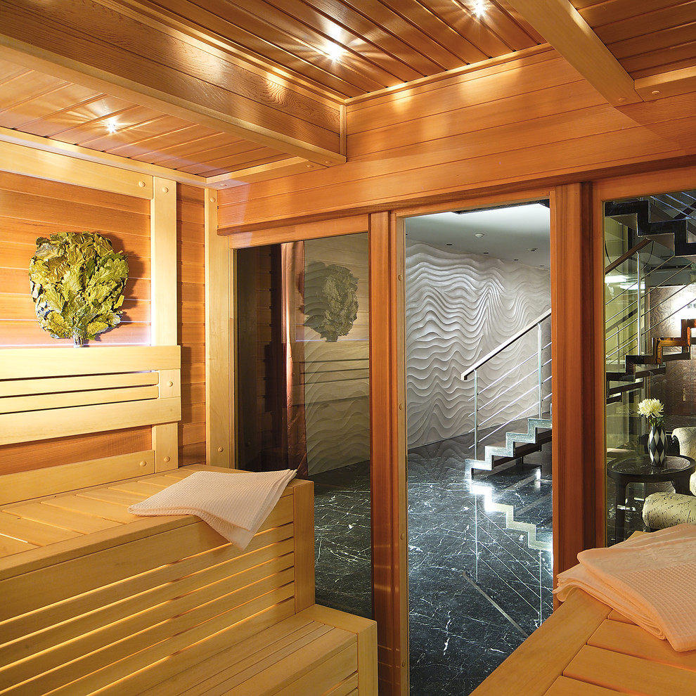 Aménagement d'une piscine intérieure contemporaine avec une terrasse en bois.