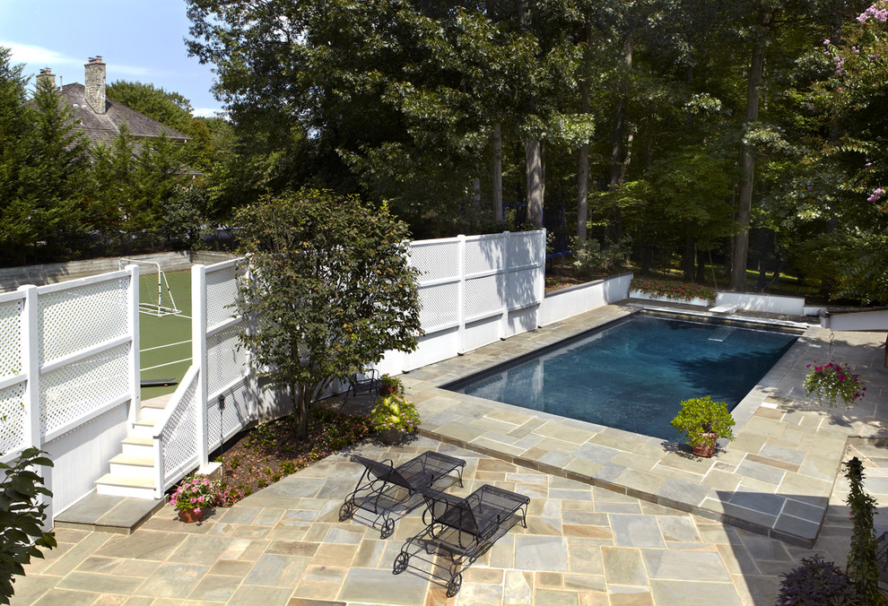 Imagen de piscina alargada clásica de tamaño medio rectangular en patio trasero con adoquines de hormigón