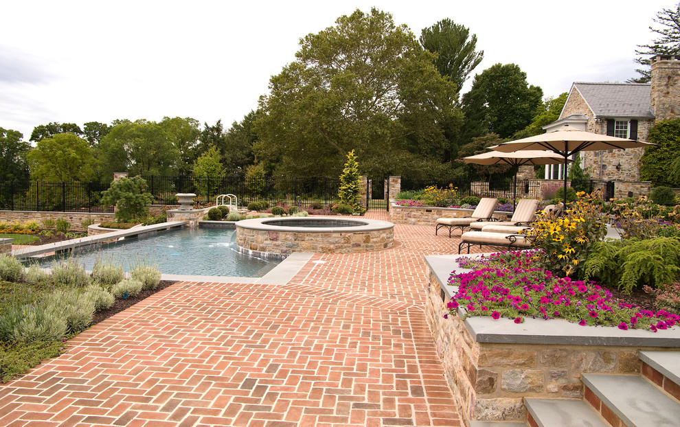 Foto de piscinas y jacuzzis alargados clásicos grandes a medida en patio trasero con adoquines de ladrillo