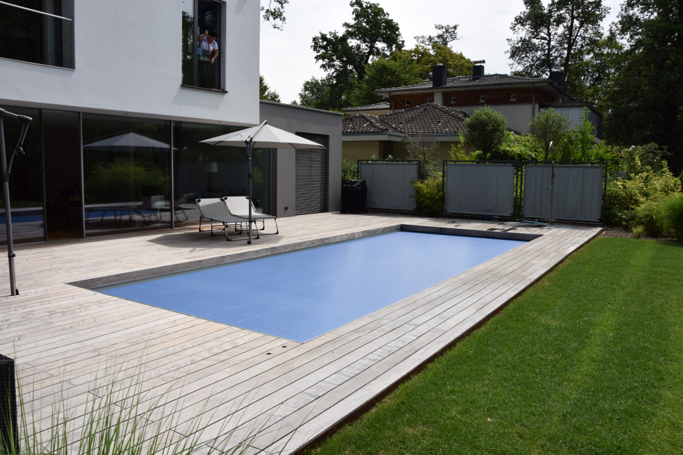 Foto de piscina clásica grande rectangular en patio lateral con entablado