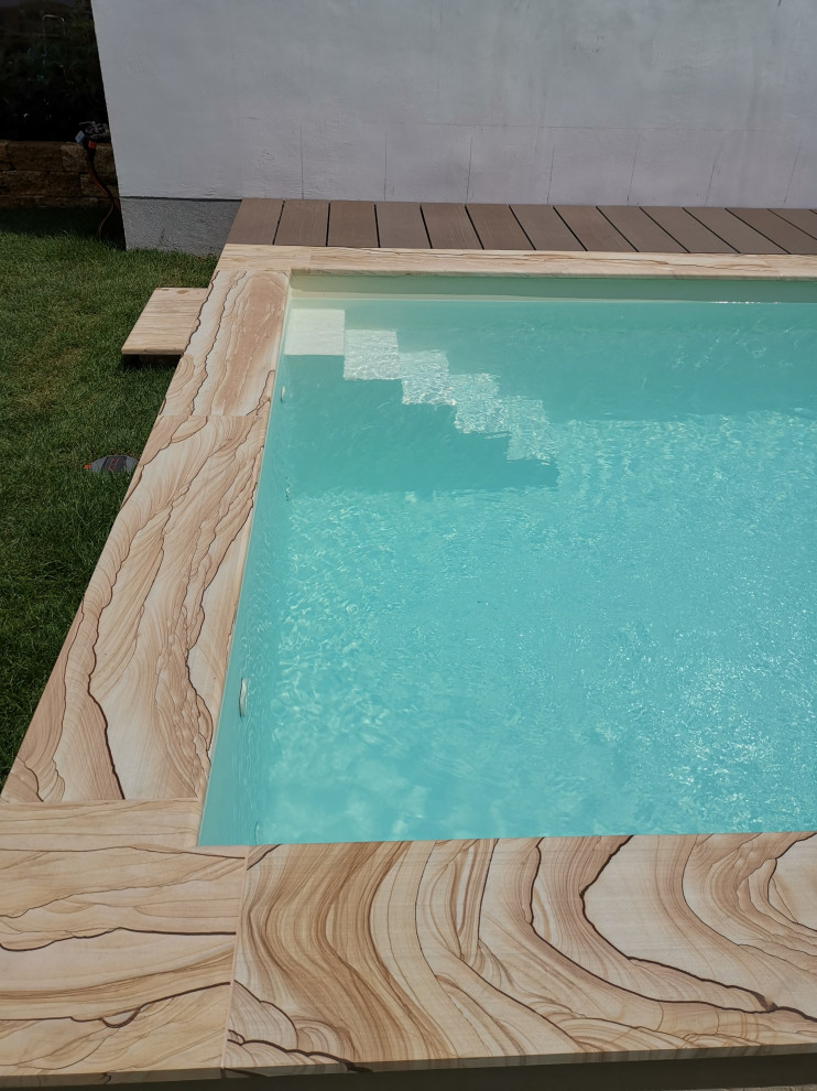 Inspiration för en liten rektangulär pool framför huset, med naturstensplattor