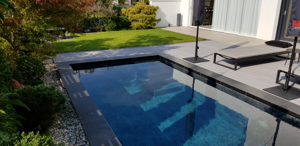 Kleiner Mediterraner Pool neben dem Haus in rechteckiger Form mit Natursteinplatten in Frankfurt am Main