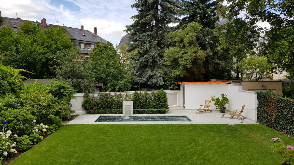 Inspiration för en liten funkis rektangulär pool längs med huset, med naturstensplattor