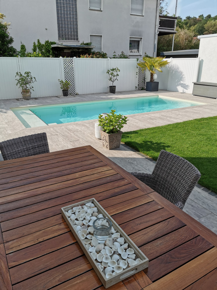 Imagen de piscina mediterránea de tamaño medio rectangular en patio lateral con suelo de baldosas
