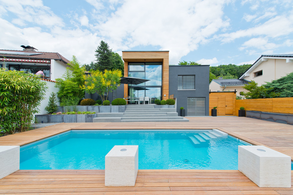 Réalisation d'un couloir de nage arrière design de taille moyenne et rectangle avec une terrasse en bois.