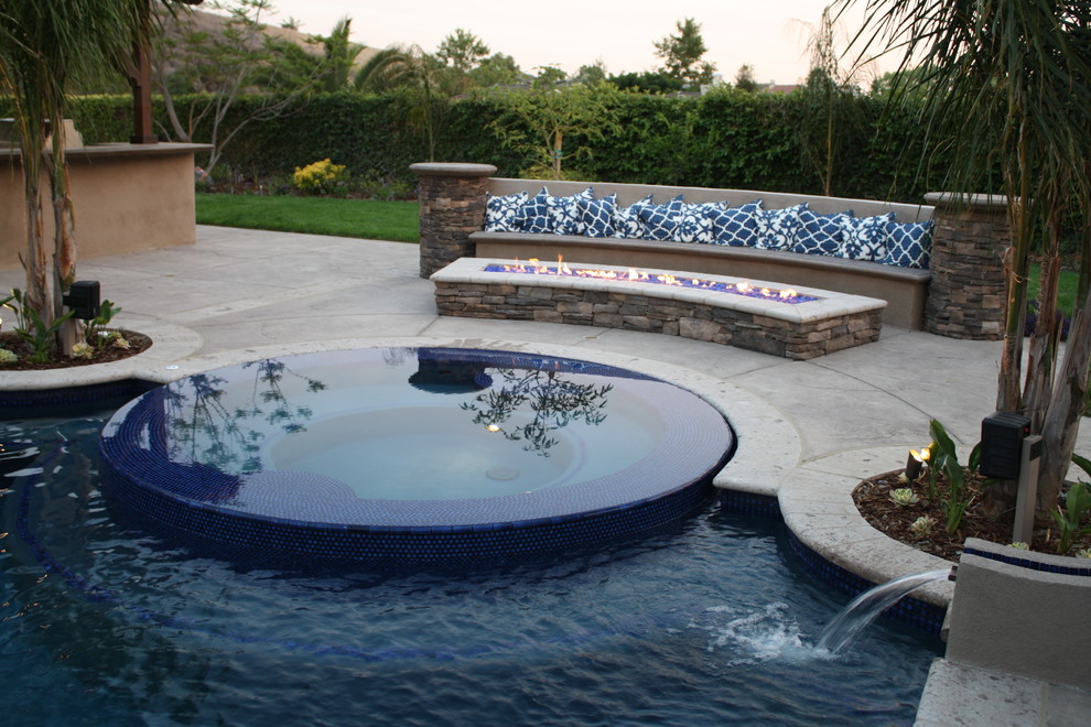 Esempio di una grande piscina a sfioro infinito mediterranea personalizzata dietro casa con una vasca idromassaggio