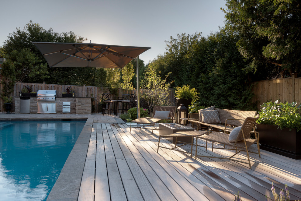 Aménagement d'une piscine contemporaine rectangle avec une terrasse en bois.