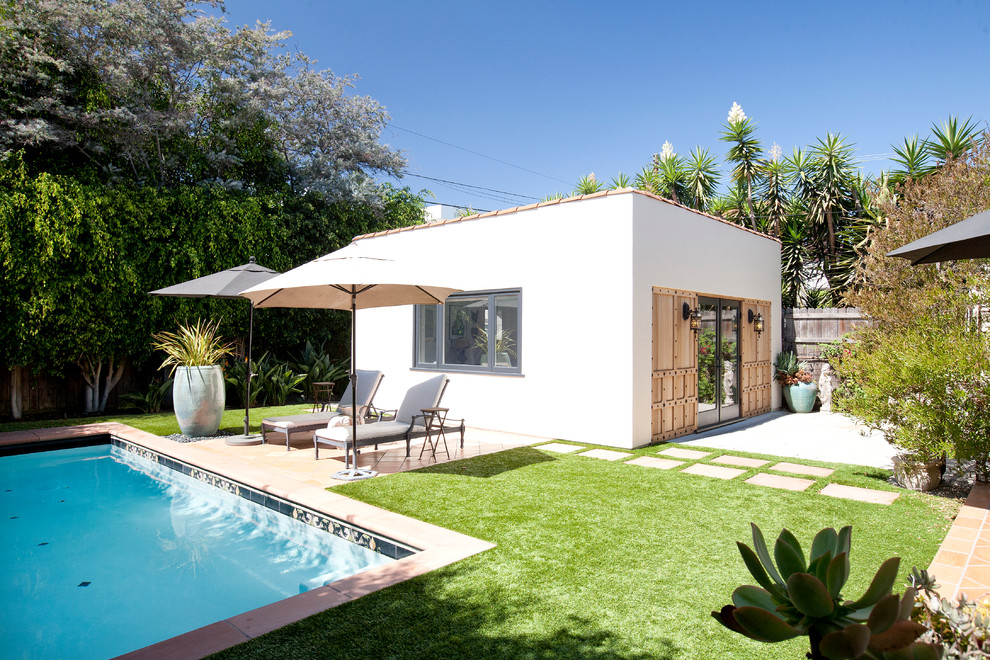 Foto di una piscina monocorsia minimal rettangolare dietro casa con una dépendance a bordo piscina e piastrelle