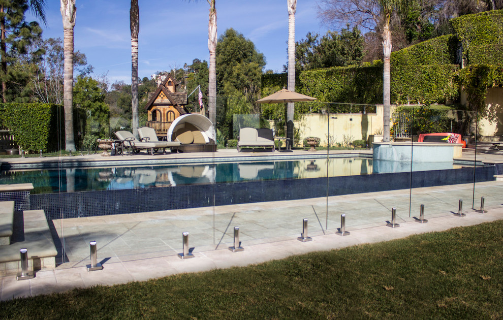 Ispirazione per una grande piscina minimal personalizzata dietro casa con una vasca idromassaggio e pavimentazioni in cemento