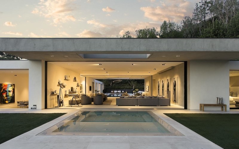 Foto de piscina infinita moderna grande rectangular en patio trasero con adoquines de hormigón