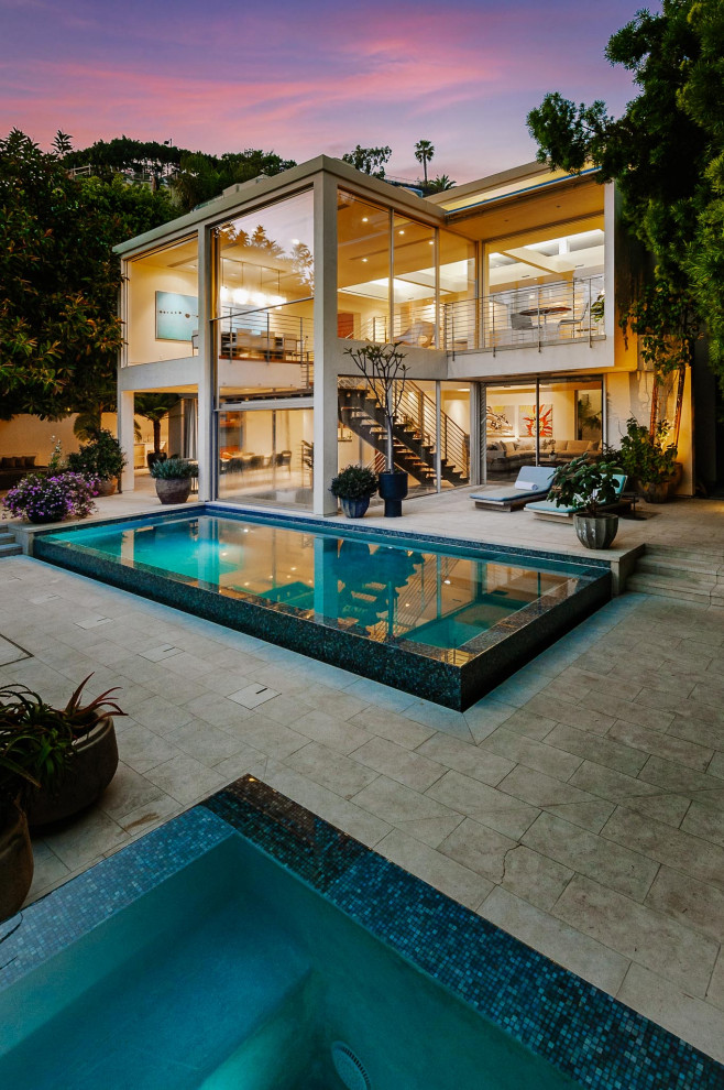 Стильный дизайн: большой прямоугольный бассейн-инфинити на заднем дворе в стиле модернизм с джакузи - последний тренд