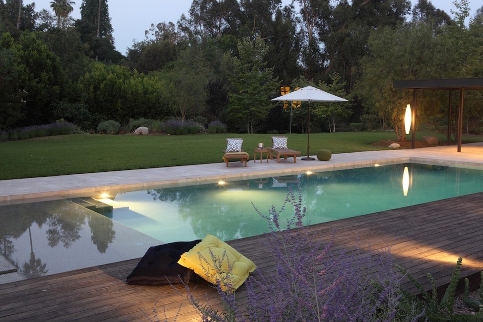 Réalisation d'une piscine méditerranéenne rectangle avec une terrasse en bois.
