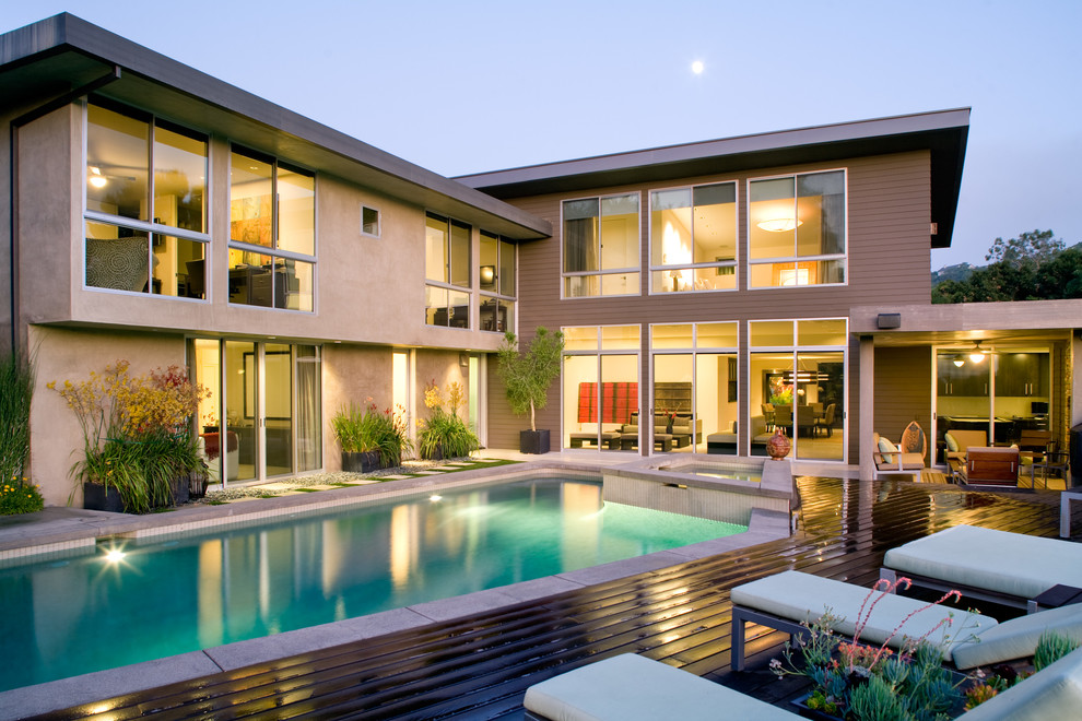 Immagine di una piscina design dietro casa con pedane
