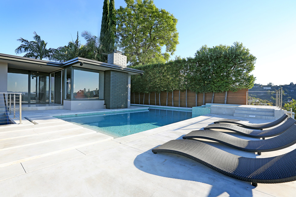 Idee per una piscina moderna a "L" con lastre di cemento