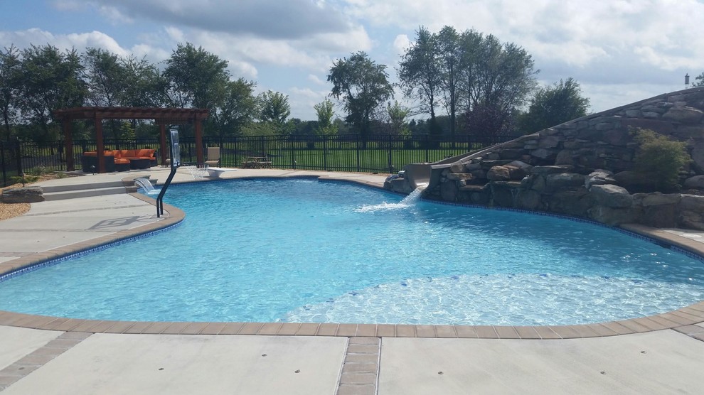 Immagine di una piscina personalizzata di medie dimensioni e dietro casa con fontane e pavimentazioni in cemento